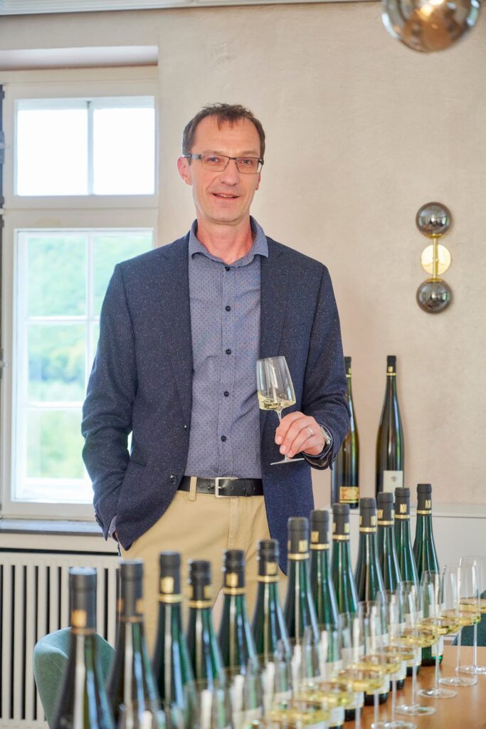 Dr Karsten Weynand, Inhaber des Weinguts Reichsgraf von Kesselstatt, mit einem Glas Wein in der Hand bei einer Weinprobe
