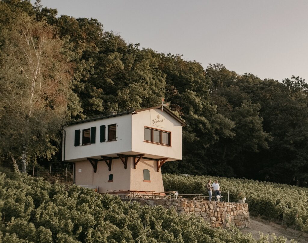 Das Weingut der Familie Diefenhardt im Weinberg. Zwei MEnschen stehen auf der Terassen und unterhalten sich