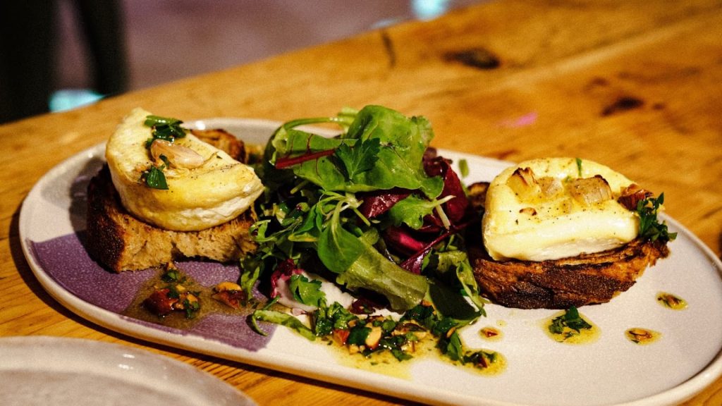 Ein Teller mit Brot, Camembert und Salat